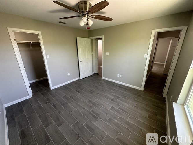A room with a ceiling fan and tile flooring.