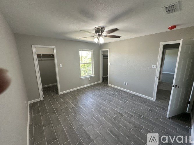 A room with a ceiling fan and tile flooring.
