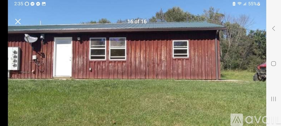 A red wooden building with a white door and windows.