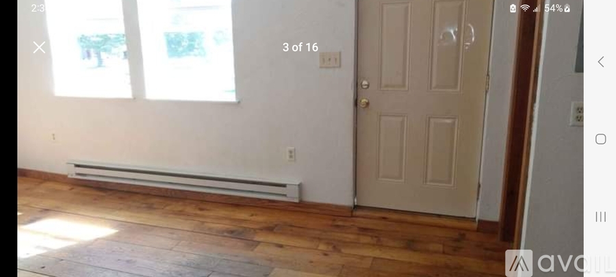 A room with a door, window, and radiator.
