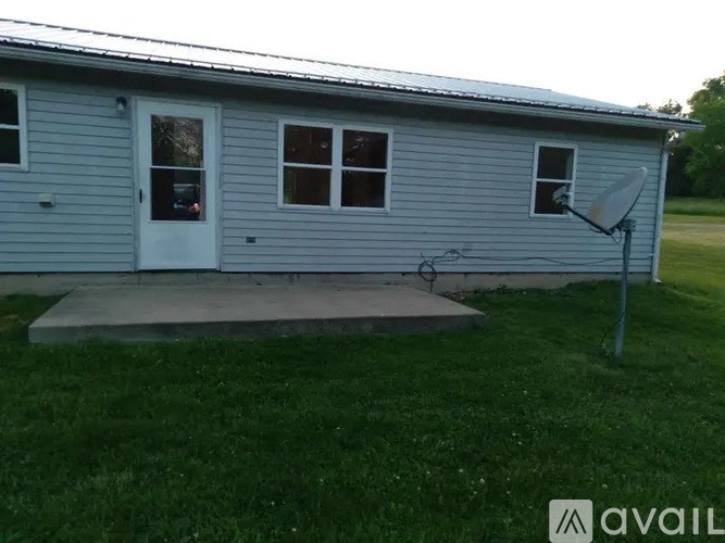 A red ATV is parked on a driveway.