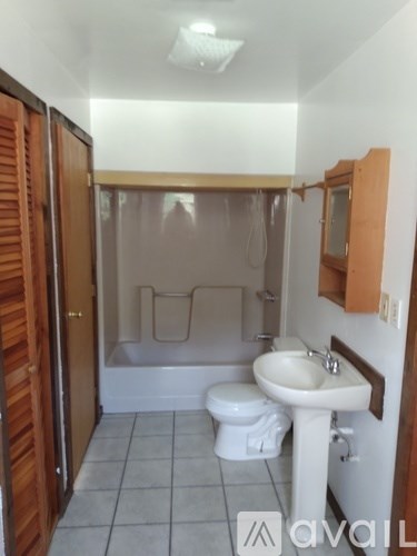 A bathroom with a toilet, sink and shower.