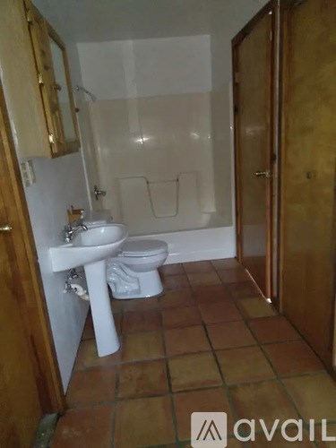 A bathroom with a toilet, sink, and shower.