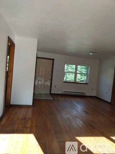 A room with wooden floors and a window.