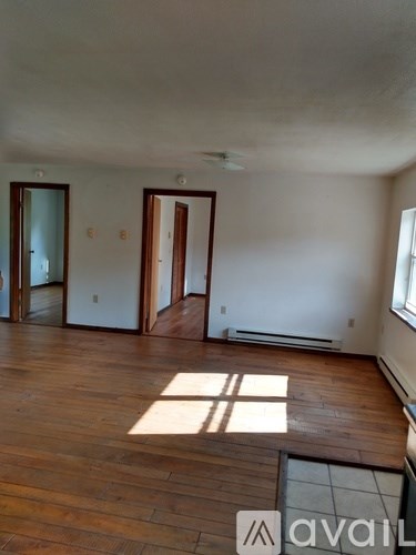 A room with wooden floors and two doors.