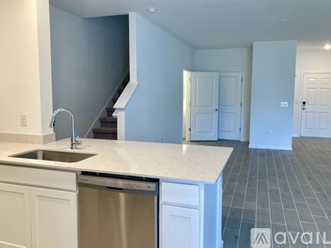 A kitchen with a stainless steel dishwasher and a sink.