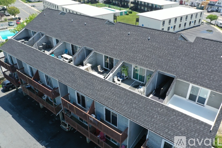 A large building with a grey roof and multiple balconies.