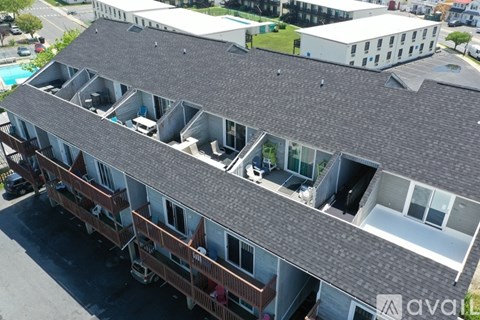 A large building with a grey roof and multiple balconies.