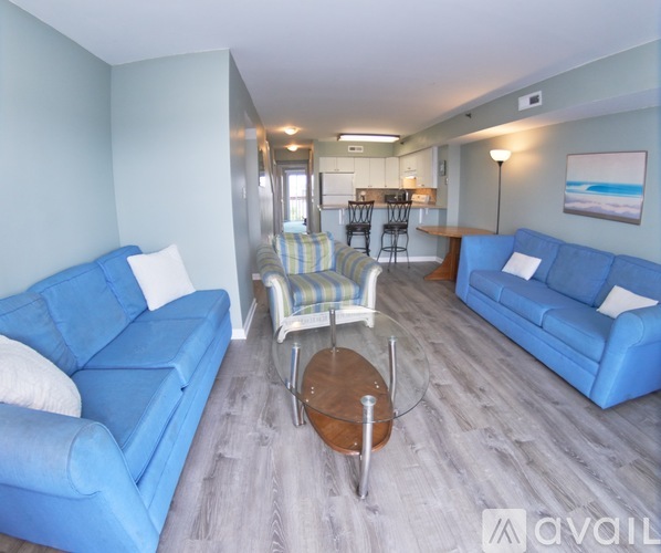A living room with blue couches and a wooden coffee table.