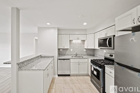 A modern kitchen with granite countertops and stainless steel appliances.