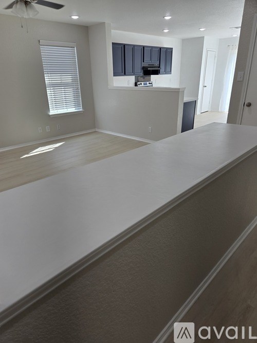 A spacious room with a long counter and a ceiling fan.