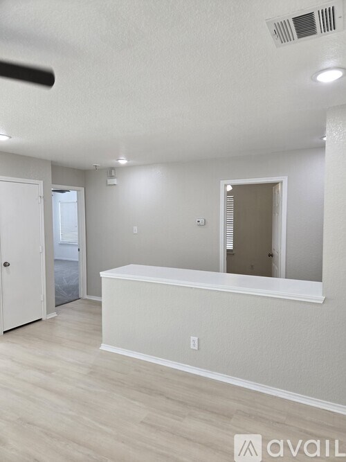 A room with a white counter and a mirror on the wall.