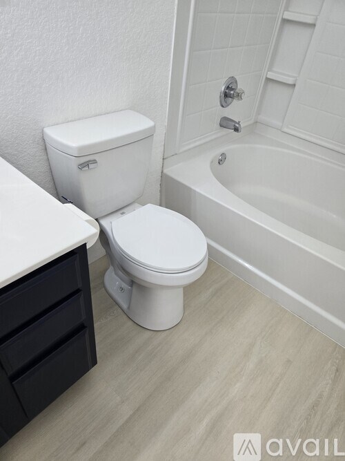 A white toilet sits next to a bathtub in a bathroom.