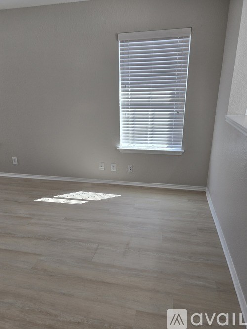 A room with a window and wooden flooring.