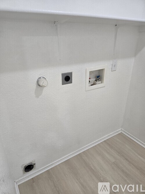 A white wall with a circular hole and a square hole with a white square in the middle.