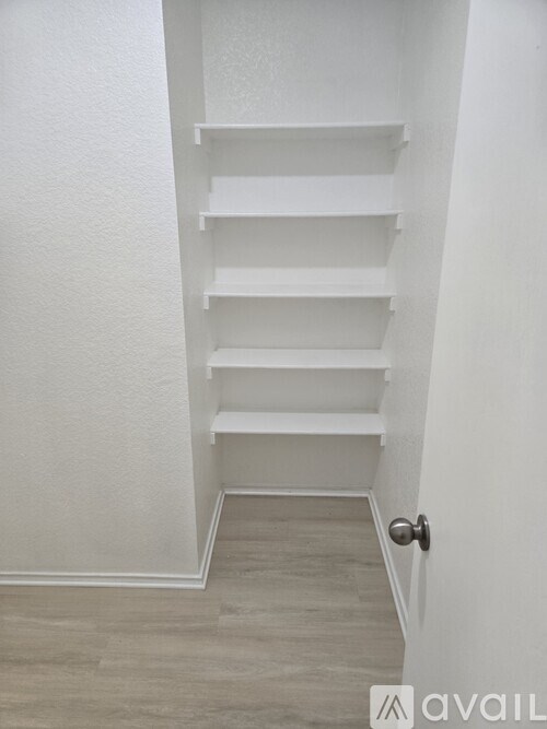 A white shelving unit in a hallway.