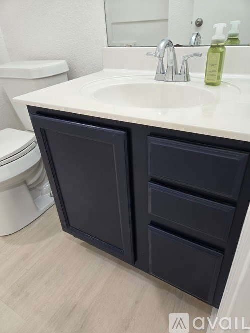 A bathroom with a white sink and a white toilet.