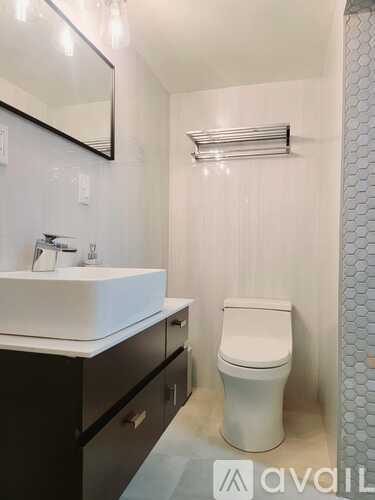 A white toilet sits next to a sink in a bathroom.