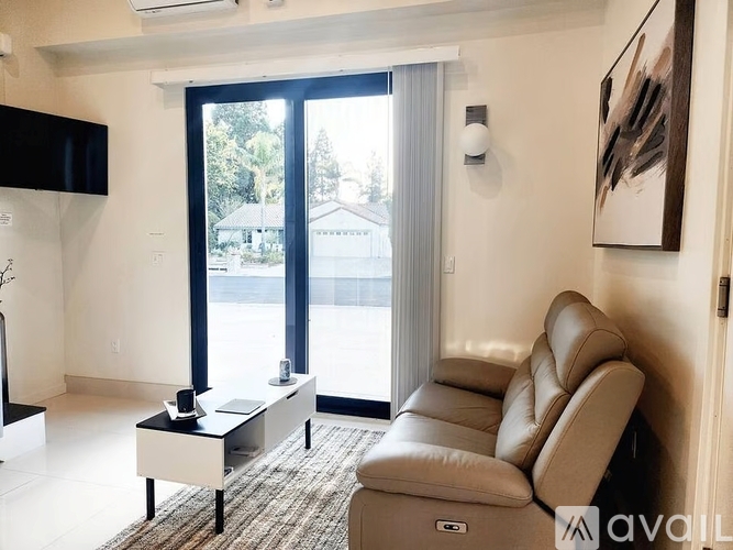 A living room with a couch, a coffee table, and a painting on the wall.