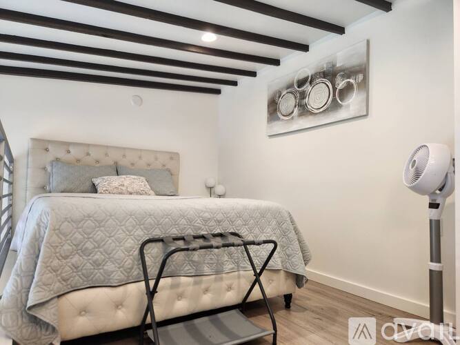 A bedroom with a large bed and a wooden ceiling.
