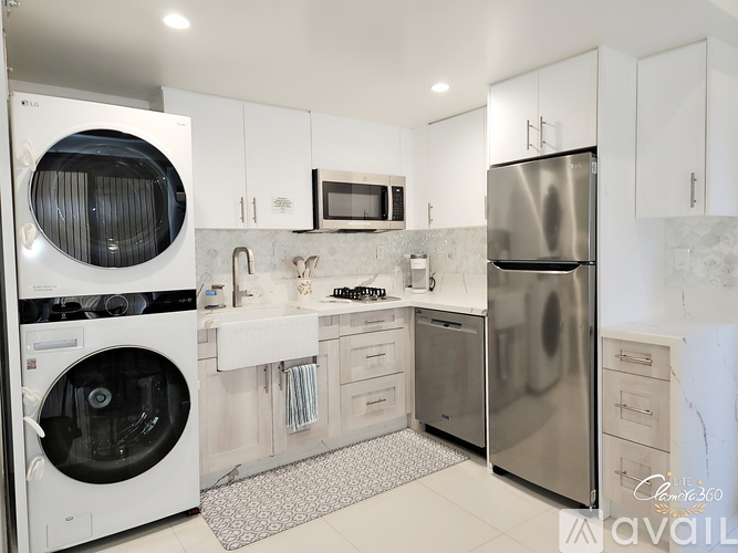 A kitchen with a table and chairs and a fridge.