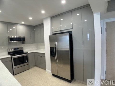 A modern kitchen with a stainless steel refrigerator and oven.