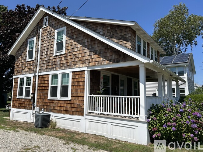 A house with a brown wooden exterior and white trim.