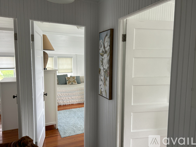 A bedroom with a bed and a painting on the wall.