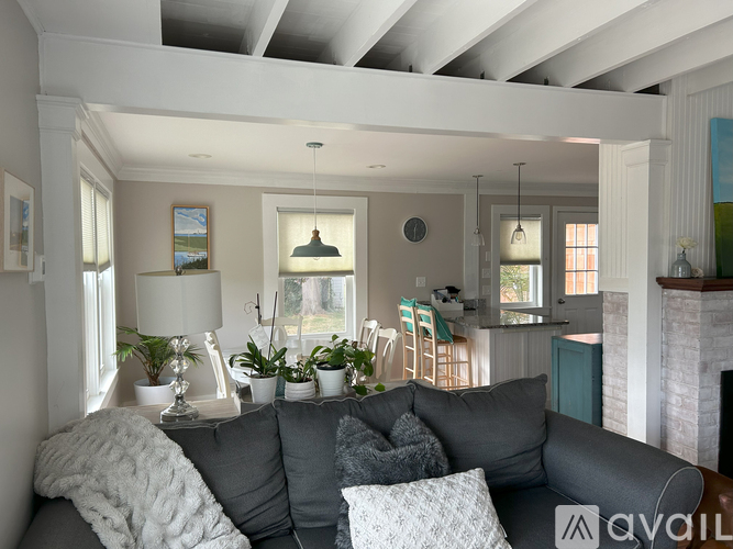 A living room with a grey couch and a fireplace.