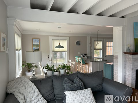 A living room with a grey couch and a fireplace.