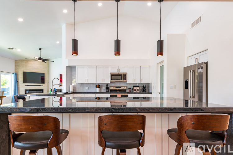 A modern kitchen with a bar counter and chairs.