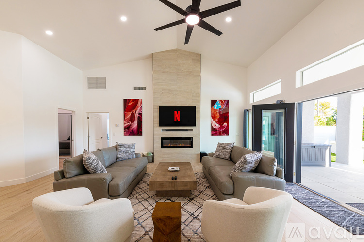 A living room with a grey couch and a white chair.