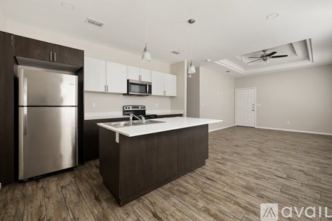 A kitchen with a refrigerator, microwave, and a countertop.