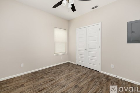 A room with a ceiling fan and a white door.