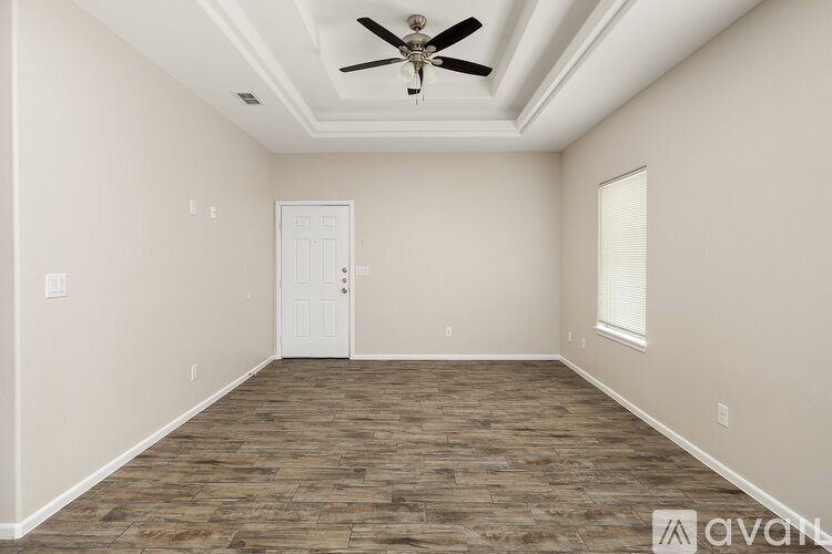 A room with a ceiling fan and wooden flooring.
