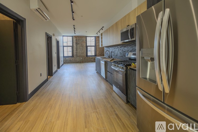 A kitchen with wooden floors and stainless steel appliances.