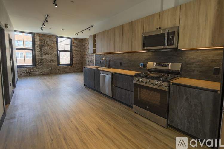 A kitchen with wooden cabinets and a brick wall.