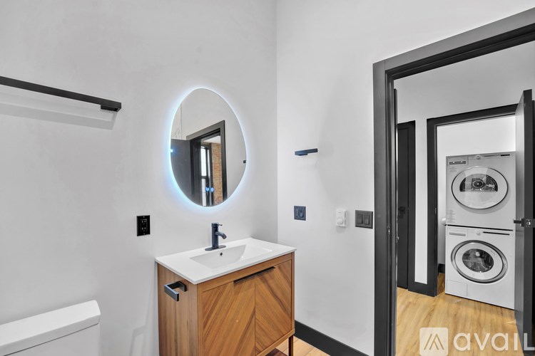 A bathroom with a round mirror and a wooden vanity.