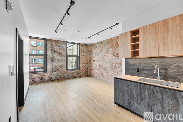 A staircase with a brick wall on one side and a mirror on the other.