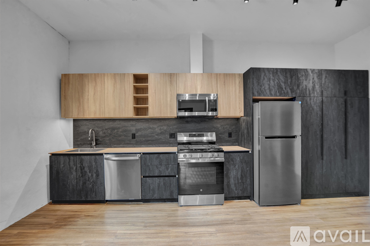 A modern kitchen with stainless steel appliances and wooden floors.