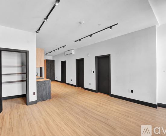 A room with a brick wall and wooden floors has a large open door.
