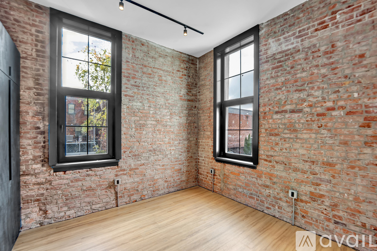 A black and wood interior space with a window showing a balcony.
