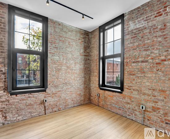 A black and wood interior space with a window showing a balcony.