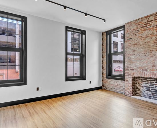 A room with a wooden floor and a black door.