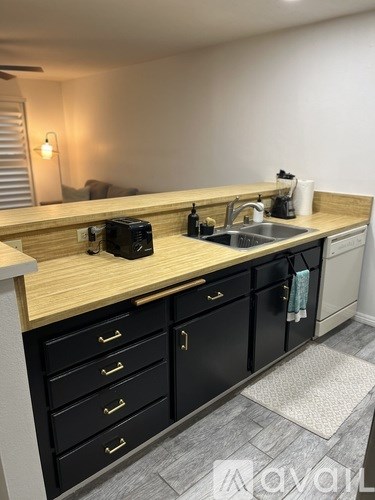 A kitchen with black cabinets and a wooden countertop.