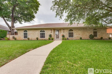 A house with a lawn and a tree in front.