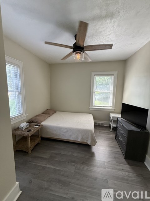 A bedroom with a bed, dresser, and window.