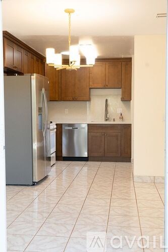 A kitchen with a refrigerator, dishwasher and a sink.