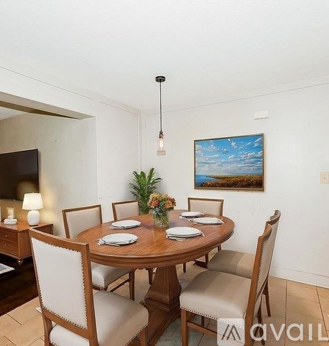 A dining room with a wooden table set for four.