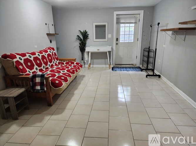 A living room with a couch, a table, and a chair.